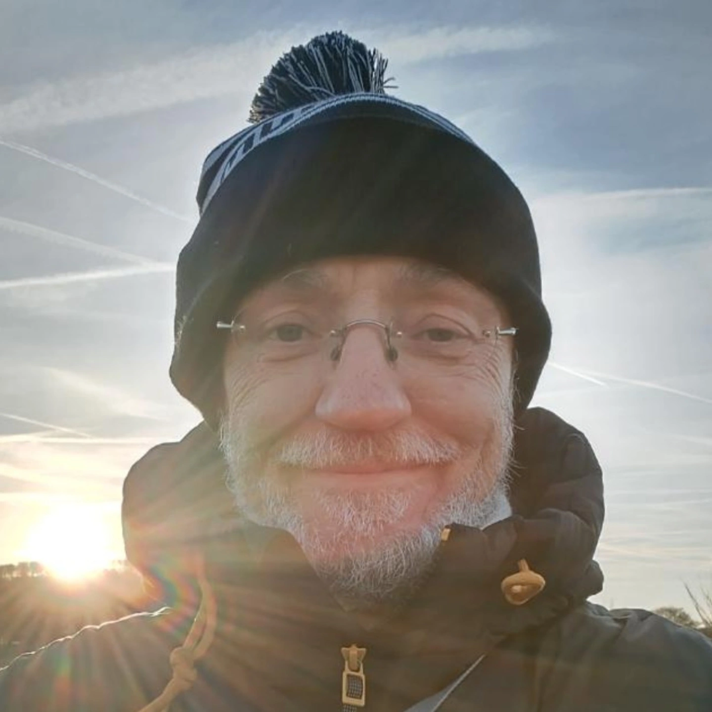Man wearing bobble hat and rimless glasses 