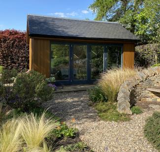 Garden Room studio in spring sunshine shows gravel path and single step